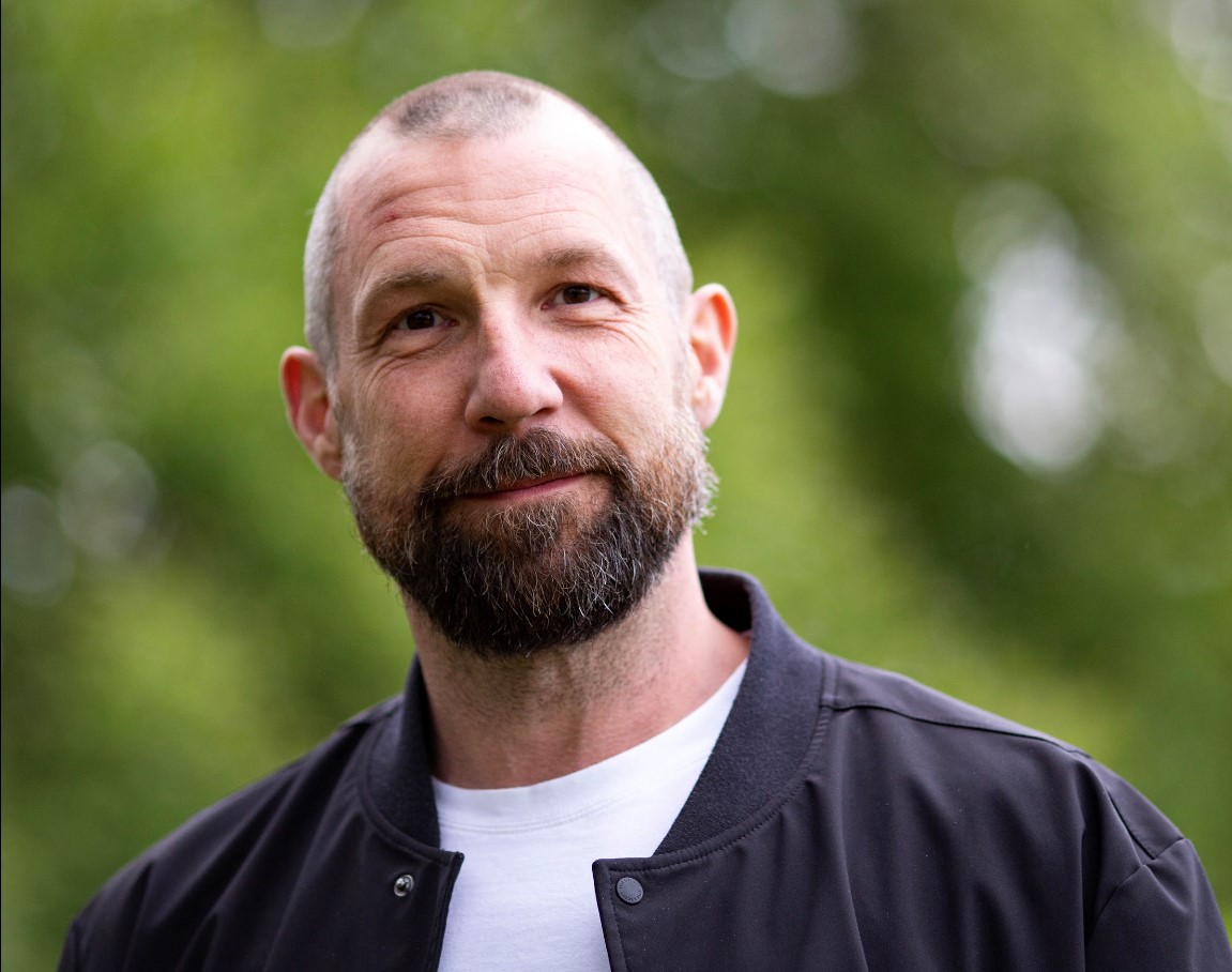 Jimmy Fagerberg, certifierad Web Accessibility Specialist, utomhus med grön bakgrund